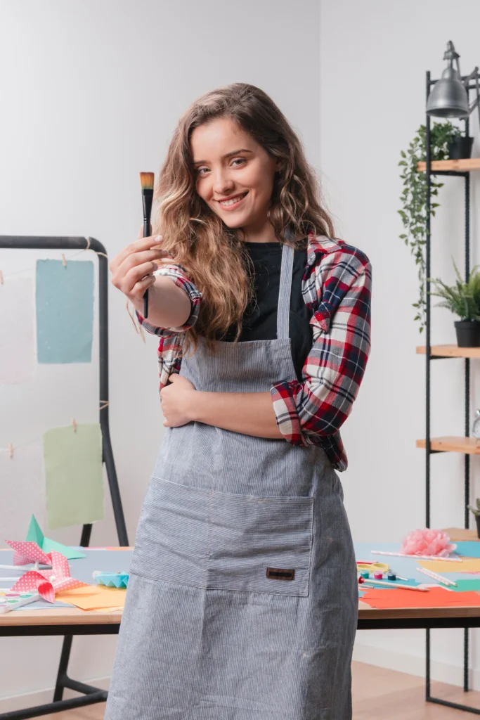 smiling young woman showing black paintbrush