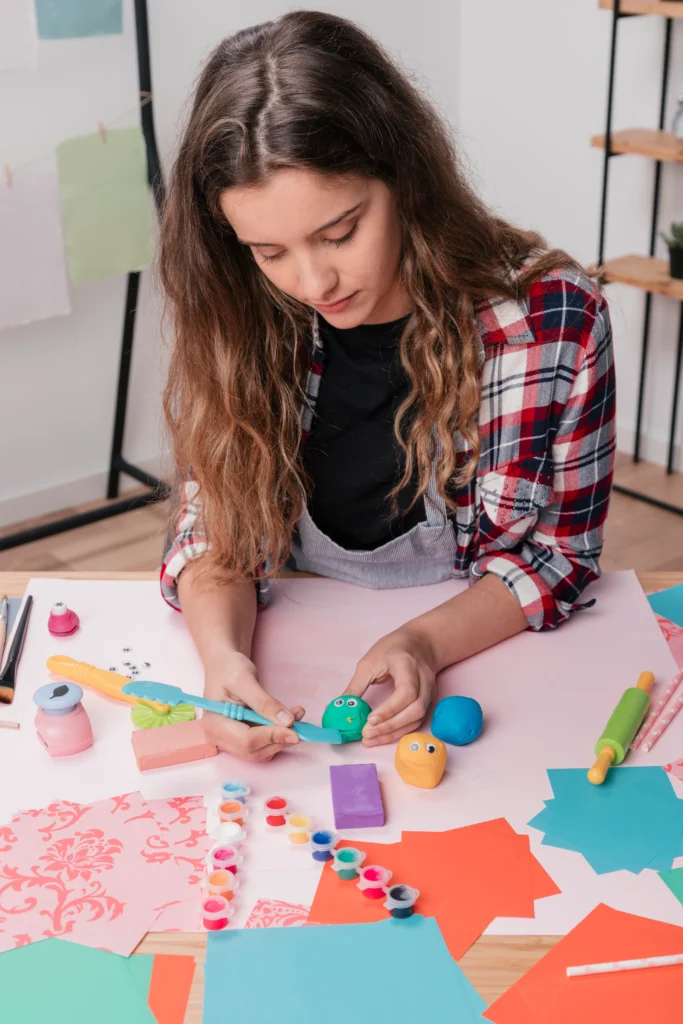 woman carving colorful clay making cartoon face