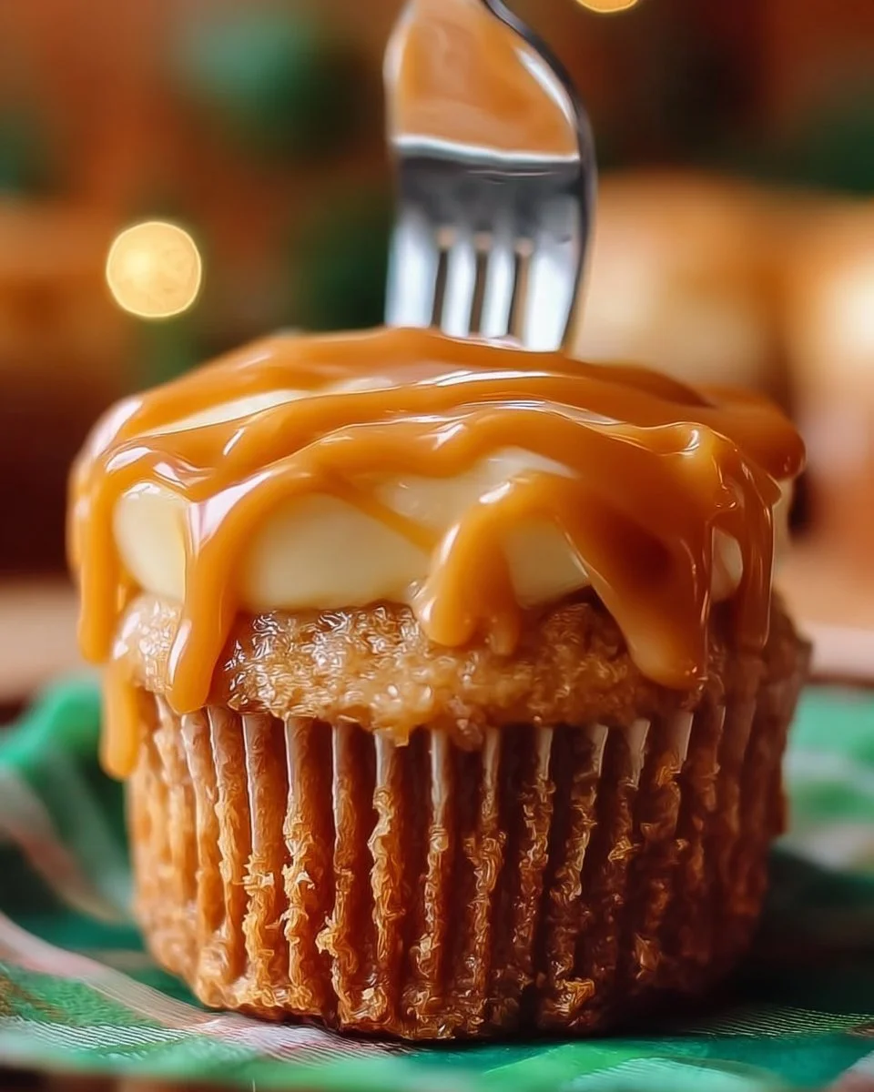 Delicious homemade caramel apple cupcakes topped with caramel drizzle and apple slices.