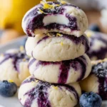 Lemon blueberry cheesecake cookies on a white plate with blueberries