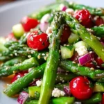Fresh asparagus salad with cherry tomatoes and feta cheese served in a bowl